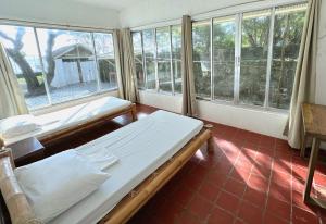 1 dormitorio con 2 camas en una habitación con ventanas en White House, Batangas en Lian
