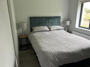 a bedroom with a large bed and two lamps at Stylish Killorglin Apartment in Killorglin