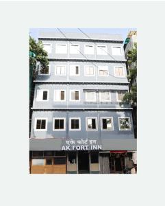 un bâtiment blanc avec un panneau qui dit de lier l'art pour lui dans l'établissement Hotel A K Fort Inn, à Mumbai