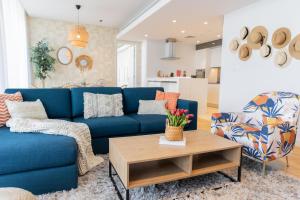 a living room with a blue couch and a table at HiGuests - Colorful Apartment in Bluewaters Close to Beach in Dubai