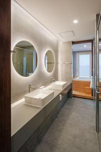 baño con 2 lavabos y bañera con 2 espejos en Hotel Cielo, en Siheung