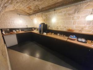 a kitchen with a counter and a brick wall at Hipotel Paris Père-Lachaise République in Paris +22 photos