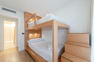 a bedroom with two bunk beds with white sheets at Apartamento Sevilla Centro in Seville
