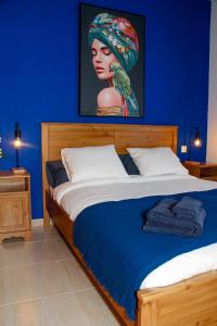 a bedroom with a bed with a blue wall at Malvasía House in Costa Teguise