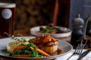 un plato de comida con carne y verduras en una mesa en The Red Lion & Manor House, en Burnsall