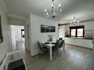 - une salle à manger et une cuisine avec une table et des chaises dans l'établissement Veneția Apartament - Timisoara, à Timişoara