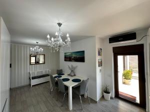 une salle à manger avec une table, des chaises et un lustre dans l'établissement Veneția Apartament - Timisoara, à Timişoara