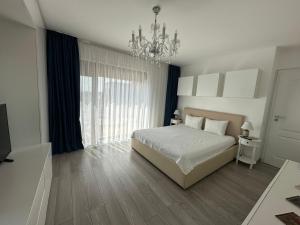 1 dormitorio con cama y lámpara de araña en Veneția Apartament - Timisoara, en Timisoara