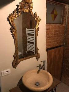 ein Bad mit einem Waschbecken und einem Wandspiegel in der Unterkunft Monolocale Vasari in Arezzo