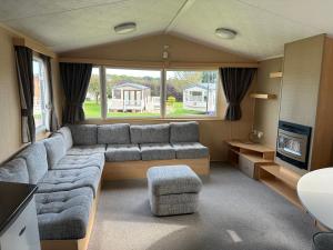 a living room with a couch and a tv at parkdean cherry tree park in Belton