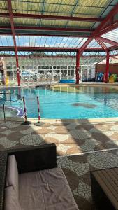 a large swimming pool with blue water in a building at parkdean cherry tree park in Belton