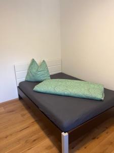 a bed with two blue pillows on top of it at Ferienwohnung mit wunderschöner Bergkulisse in Matrei in Osttirol