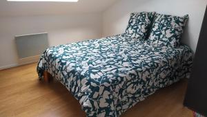 a bedroom with a bed with a blue and white blanket at Appartement FX 3 in Saint Die