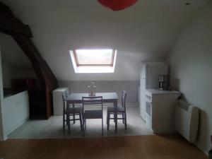 une cuisine avec une table et des chaises ainsi qu'une fenêtre dans l'établissement Appartement FX 3, à Saint-Dié-des-Vosges