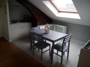 une cuisine avec une table et des chaises ainsi qu'une fenêtre dans l'établissement Appartement FX 3, à Saint-Dié-des-Vosges