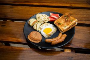 un piatto di prodotti per la colazione con salsiccia e pane tostato di Trippers hostel a Darjeeling