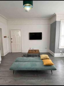 ein Wohnzimmer mit einem Bett und einem Flachbildfernseher in der Unterkunft Lovely 1-bedroom apartment, free street parking in Elswick