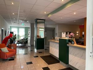 an office lobby with a reception desk and a chair at ACHAT Hotel Monheim am Rhein in Monheim