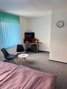 een kamer met een bed en twee stoelen en een tafel bij Hotel CAVOK letiště Příbram in Drásov