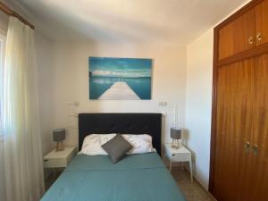 een slaapkamer met een blauw bed en 2 nachtkastjes bij Lightbooking El Burrero in Ingenio
