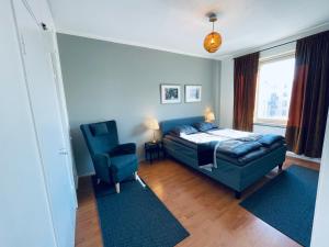 um quarto com uma cama e uma cadeira azul em STAY Kamppi Apartment em Helsinque