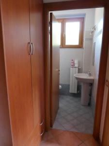baño con aseo, lavabo y puerta en Casa Marianne, en Osmate Lentate