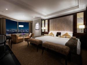 大阪市にあるホテル阪急インターナショナルの大きなベッドとテーブルが備わるホテルルームです。