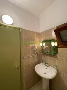 La salle de bains est pourvue d'un lavabo et d'un miroir. dans l'établissement Bora Hotel, à Gjirokastër