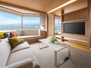 a living room with a couch and a tv at Hotel Hankyu International in Osaka