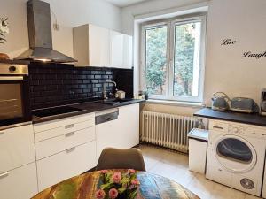 cocina con mesa, fregadero y ventana en Downtown Suite, en Düsseldorf