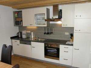 eine Küche mit weißen Schränken und einem Waschbecken in der Unterkunft Apartment Altaussee in Altaussee