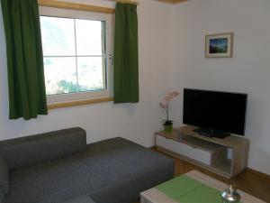 a living room with a couch and a flat screen tv at Apartment Altaussee in Altaussee