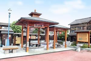 een prieel met banken voor een gebouw bij Guesthouse & Kitchen Hace in Iwaki