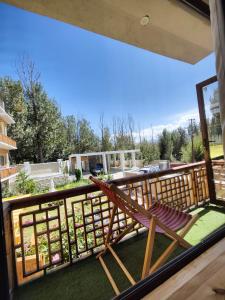 a deck with a rocking chair on a balcony at Yarab Tso in Leh