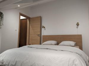 a bedroom with a large bed with white sheets at Magnifique appartement entièrement rénové au pied des pistes in Métabief