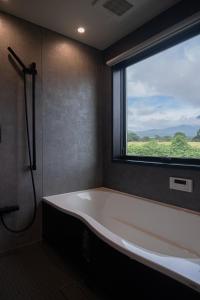 a bath tub in a bathroom with a window at VACILANDO in Fujikawaguchiko