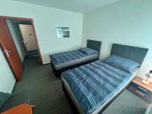 1 Schlafzimmer mit 2 Betten und einer Tür zu einem Zimmer in der Unterkunft Hotel CAVOK letiště Příbram in Drásov