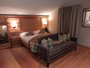 um quarto de hotel com uma cama e um sofá em Hotel Restaurant Kirchsteiger em Vollan