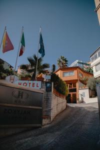 un hotel con banderas en la parte superior de una calle en Halykos Hotel, en Cammarata