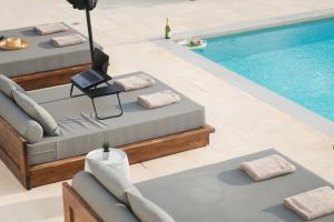 a pool with chaise lounges next to a swimming pool at Tholaria Villa in Chania +61 photos