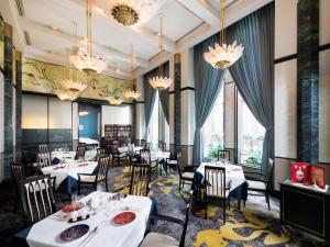 een eetkamer met tafels en stoelen en kroonluchters bij Hotel Hankyu International in Osaka