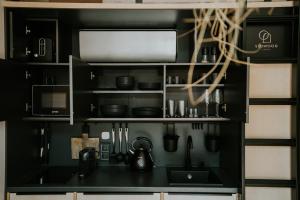 uma cozinha preta com um lavatório e um micro-ondas em Slowood Cabins em Balatonszepezd