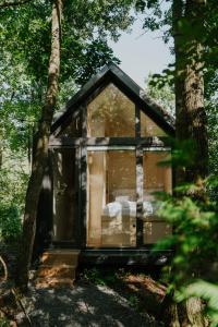 mały domek w lesie z drzewami w obiekcie Slowood Cabins w mieście Balatonszepezd