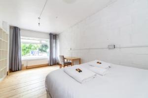 a white bedroom with a bed and a desk at Peaceful Renovated 5BDR house wgarden in London