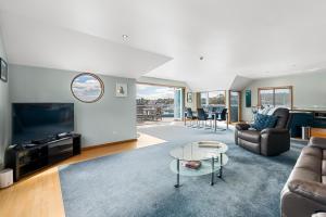 a living room with a couch and a table at Bay of Islands Apartment On The Water- The Bridge in Opua