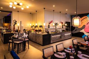 a restaurant with tables and chairs and a bar at NYX Hotel Hamburg by Leonardo Hotels in Hamburg