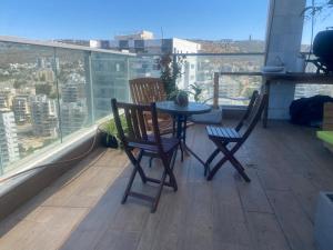 a table and two chairs on a balcony with a view at Tirat Carmel Penthouse in Tirat Karmel