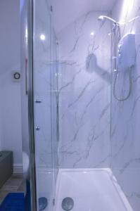 een badkamer met een douche en een glazen deur bij Superb Leighton Street House in Liverpool