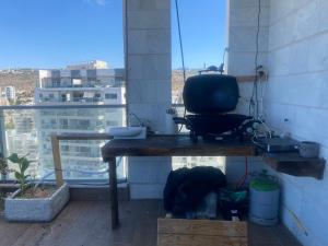 a room with a table and a view of a city at Tirat Carmel Penthouse in Tirat Karmel