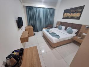 ein Hotelzimmer mit einem Bett und einem TV in der Unterkunft RR Galaxy in Gurgaon